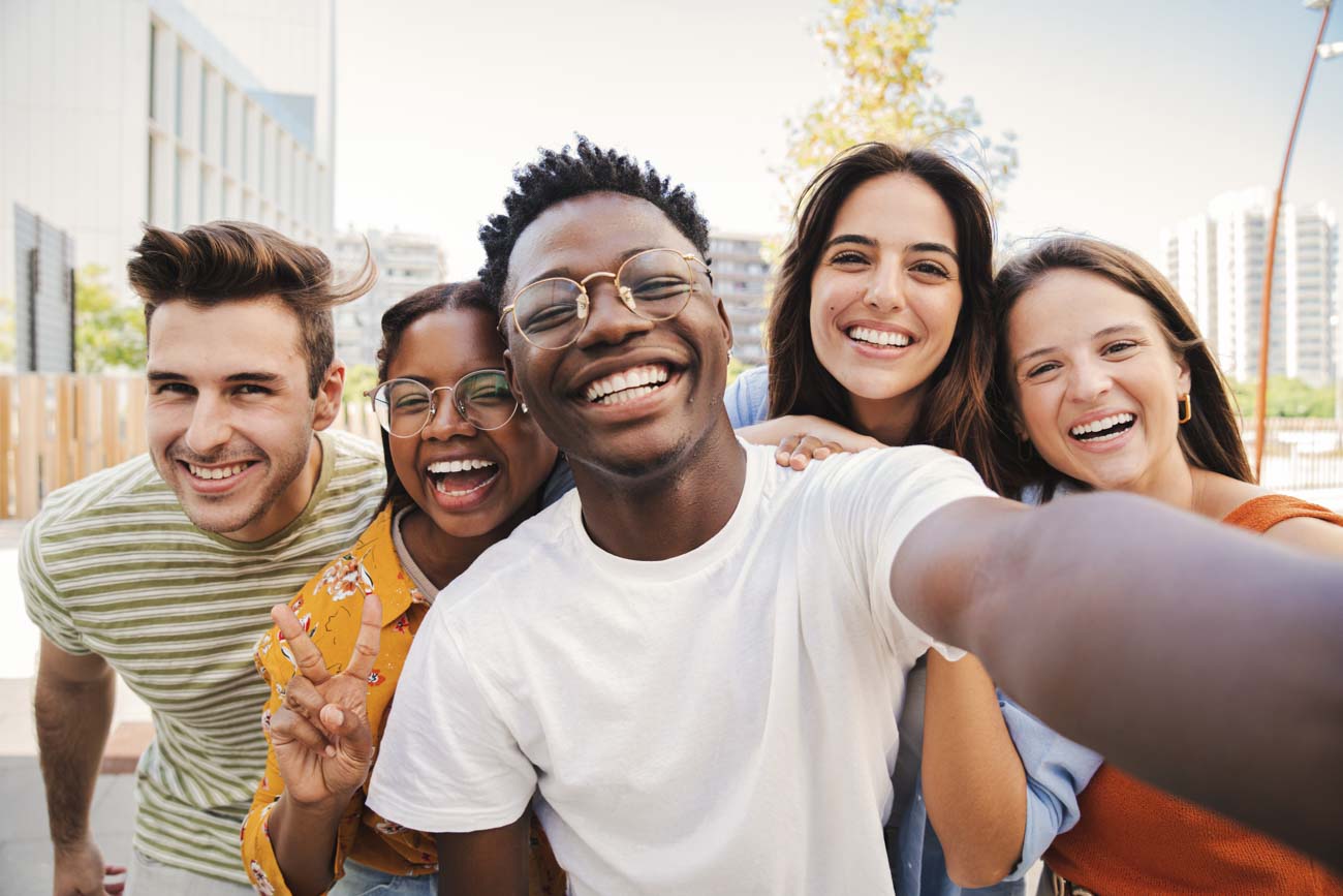 teen friends smiling and taking selfie