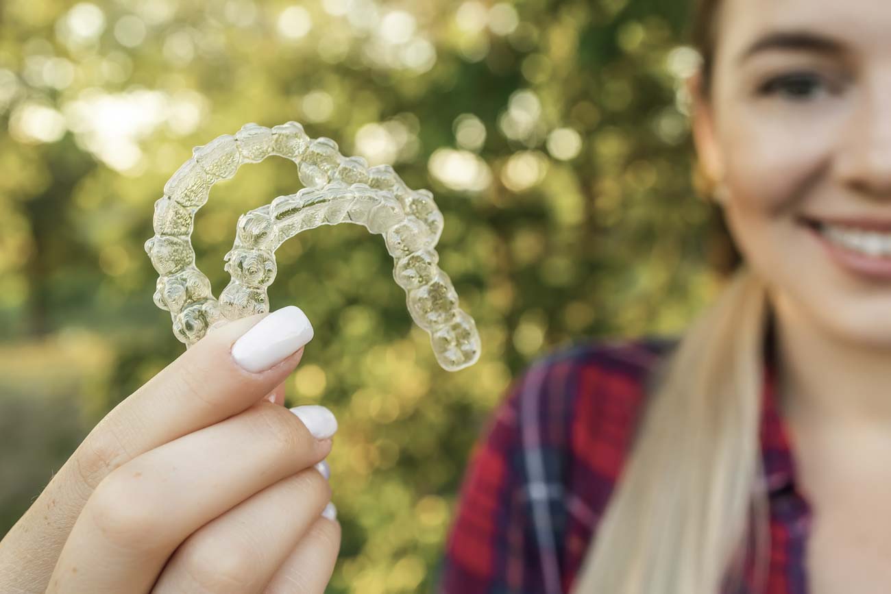 teen holding aligners