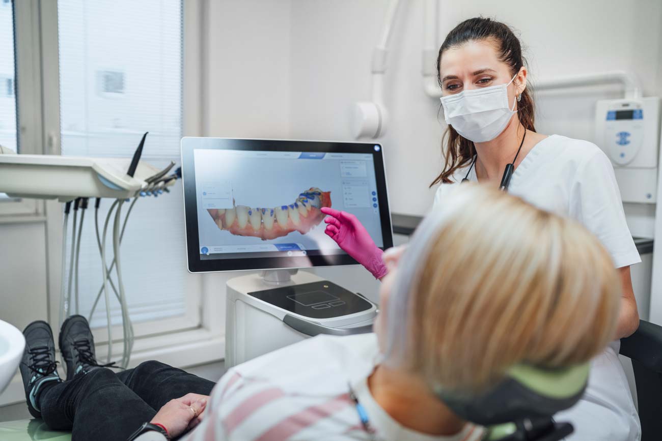 patient and staff looking at dental scan